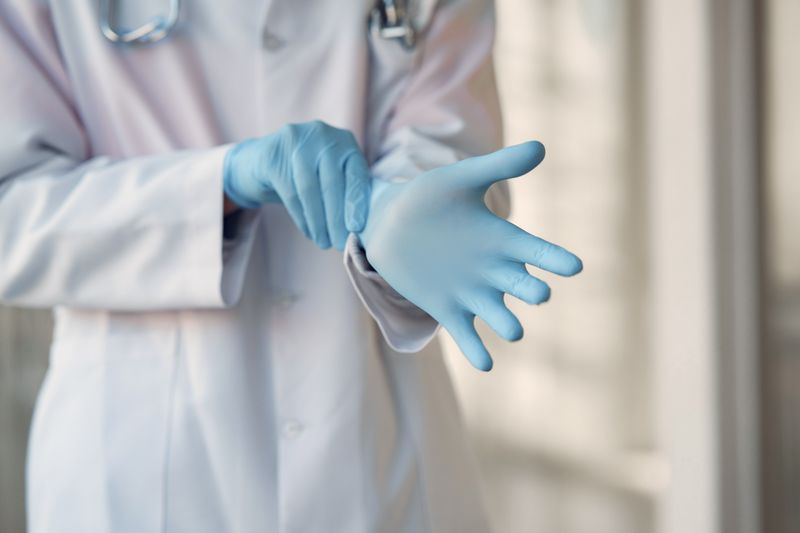 Close-up of a doctor's hand wearing a blue medical glove