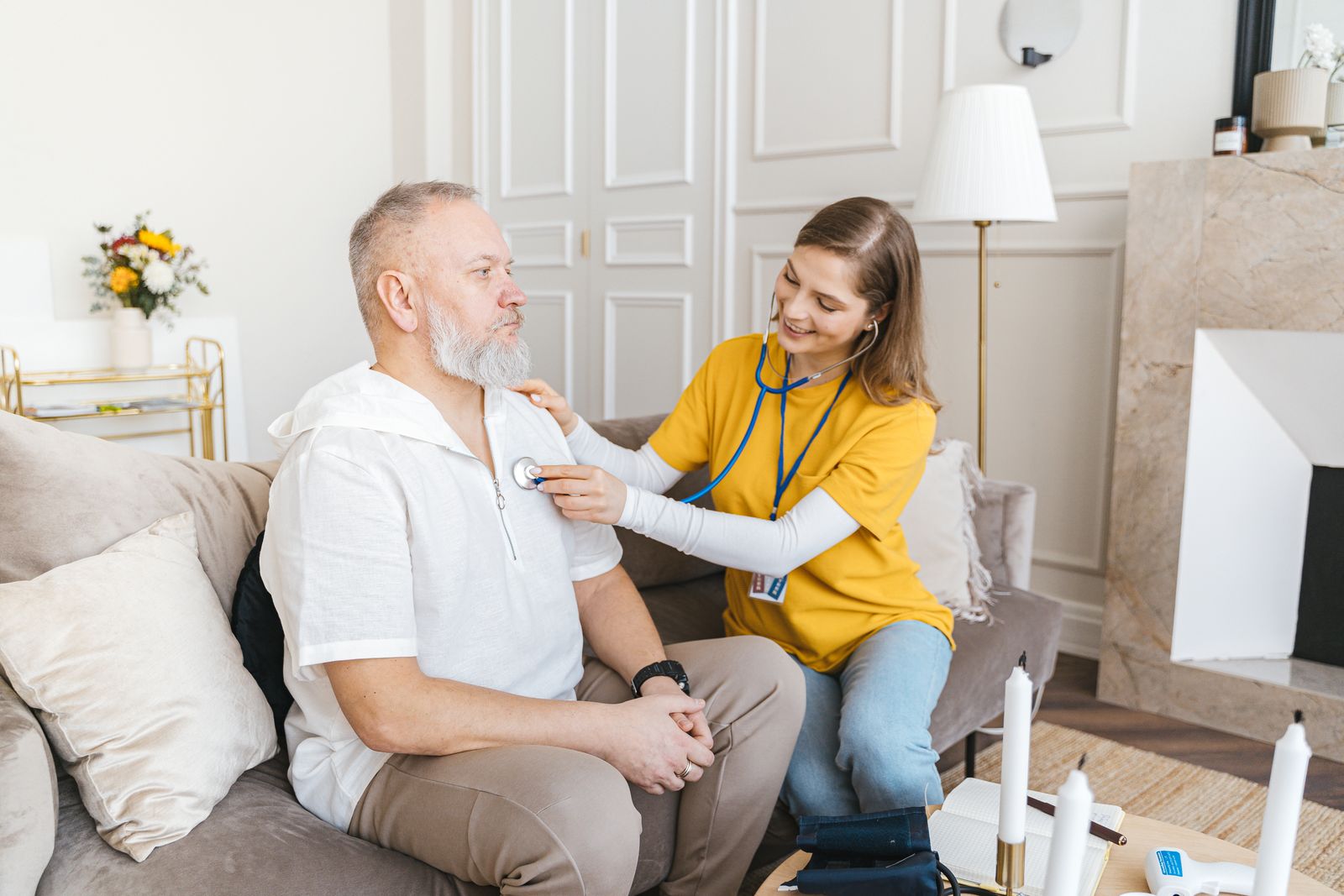 A nurse helping an older man move safely at home